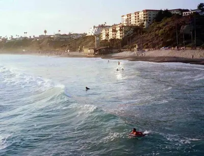 a group of people riding a wave in the ocean at Blue Whale Inn San Clemente Jewel Unit D in San Clemente