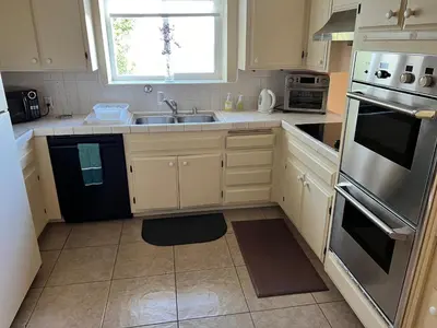 a kitchen with white cabinets and a sink at House on Organic Farm in Escondido