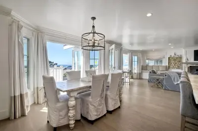 a dining room with a table and white chairs at Luxury Ocean Views & Steps To The Sand - Tower 36 Lower Condo Unit in Carlsbad