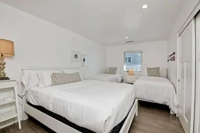 a white bedroom with two beds and a window at Luxury Ocean Views & Steps To The Sand - Tower 36 Upper Condo Unit in Carlsbad