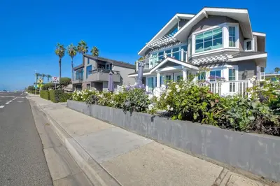 a house on the side of a street with flowers at Luxury Ocean Views & Steps To The Sand - Tower 36 Upper Condo Unit in Carlsbad