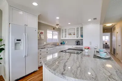 a kitchen with white cabinets and a marble counter top at Oceanfront Escape Steps to Imperial Beach! in Imperial Beach