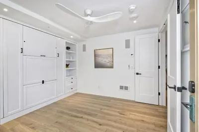 a white room with white cabinets and a ceiling fan at Oceanfront Luxury, Fully Remodeled, Five-Star in Solana Beach