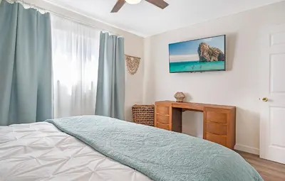 a bedroom with a bed and a dresser and a window at Sunrise by the Sea 1 Block from Ocean in Oceanside