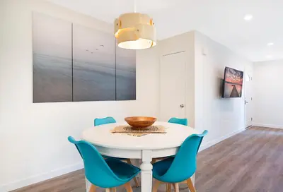 a dining room with a white table and blue chairs at Sunrise by the Sea 1 Block from Ocean in Oceanside