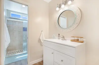 a white bathroom with a sink and a mirror at Sunrise by the Sea 1 Block from Ocean in Oceanside