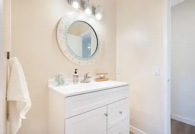 a white bathroom with a sink and a mirror at Sunrise by the Sea 1 Block from Ocean in Oceanside