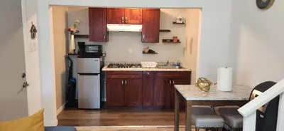 a small kitchen with wooden cabinets and a white refrigerator at New ! Lovely Studio w/ patio, Parking on premises in Escondido