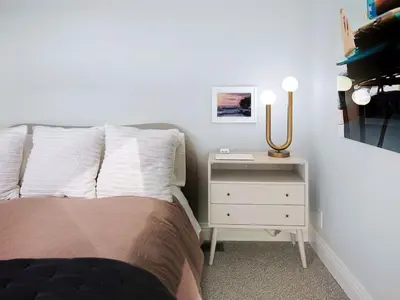 a bedroom with a bed and a night stand with a lamp at Grandview Getaway, Luxury 4BR, Ocean View, Fire Pit in Encinitas