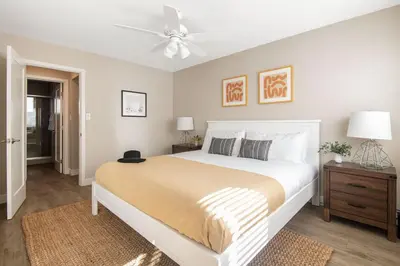 a bedroom with a white bed and a ceiling fan at Seashore Suites by AvantStay in San Diego