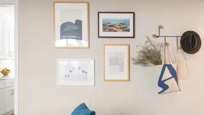 a wall with framed pictures on a white wall at Seashore Suites by AvantStay in San Diego
