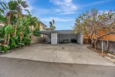 a house with a garage with a fence at ON THE SAND!! Private Beach! OCEAN FRONT HOT TUB!! in Dana Point