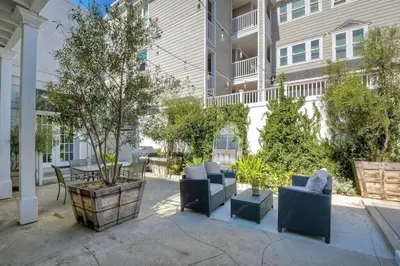 a patio with chairs and a table in front of a building at Ocean Views, Across The Street From Beach, Private Patio in Carlsbad