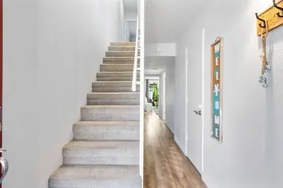 a staircase in a home with white walls and wood floors at Walk on the Ocean! Wake up to Beautiful Bay Views in Newport Beach