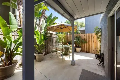a patio with a table and an umbrella at Walk on the Ocean! Wake up to Beautiful Bay Views in Newport Beach