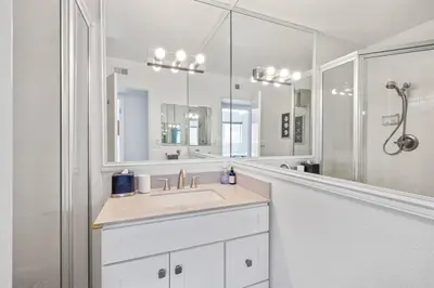 a bathroom with a sink and a large mirror at Walk on the Ocean! Wake up to Beautiful Bay Views in Newport Beach