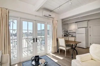 a white living room with a table and a kitchen at Ocean View From Private Patio, Steps To Beach, Parking in Carlsbad