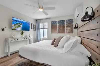 a white bedroom with a large bed and a ceiling fan at Tower 9 #2 in Oceanside