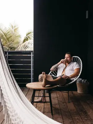 a man sitting in a chair talking on a cell phone at Twelve Senses Retreat in Encinitas