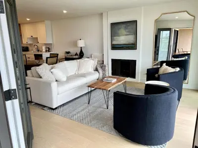 a living room with a white couch and a table at Oceanfront Fully Remodeled 2BR 2BA, Pool, Hot Tub, Gated Parking in Solana Beach