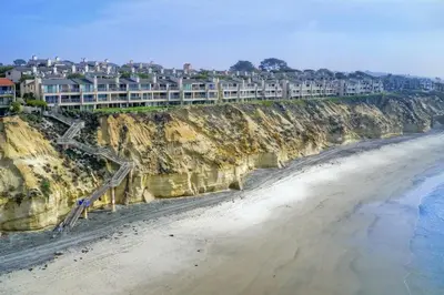 a view of a beach with buildings on a cliff at Oceanfront Fully Remodeled 2BR 2BA, Pool, Hot Tub, Gated Parking in Solana Beach
