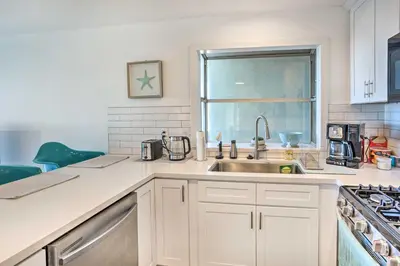 a white kitchen with a sink and a window at San Clemente Condo with Gorgeous Views Near Beach! in San Clemente