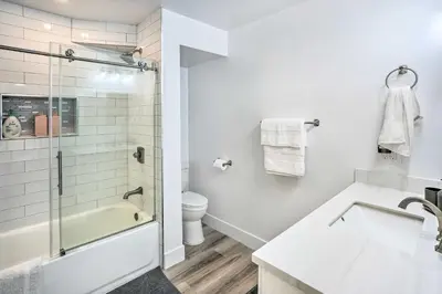 a white bathroom with a tub and a sink at San Clemente Condo with Gorgeous Views Near Beach! in San Clemente