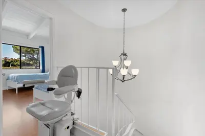 a white room with a chair and a bed at Carlsbad Hideway Pool Spa in Carlsbad