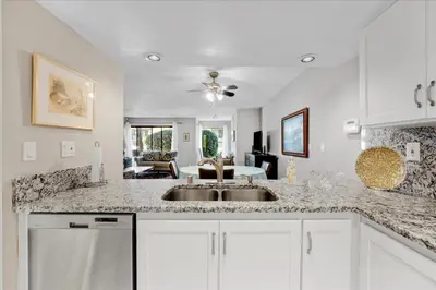 a kitchen with a sink and a living room at Carlsbad Hideway Pool Spa in Carlsbad