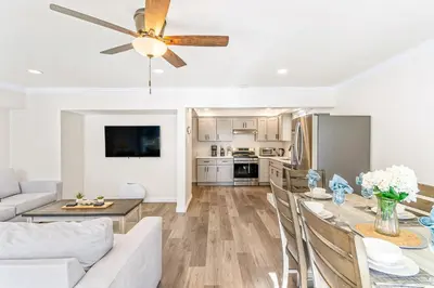 a living room with a dining room table and a ceiling fan at 4912 Seashore A Lower in Newport Beach