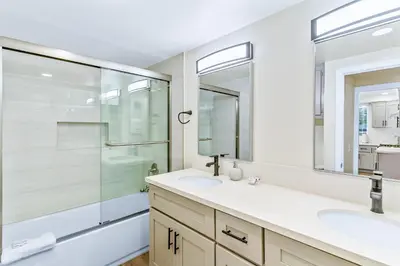 a bathroom with two sinks and a glass shower at 4912 Seashore A Lower in Newport Beach