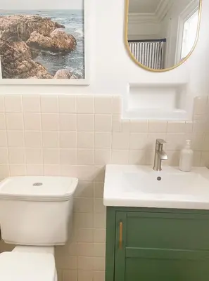 a bathroom with a sink and a toilet and a mirror at Beach house in the heart of balboa peninsula in Newport Beach