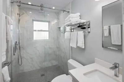 a bathroom with a shower and a toilet and a sink at Newly Renovated 3BR Modern Apt in Heart of Ocean Beach in San Diego