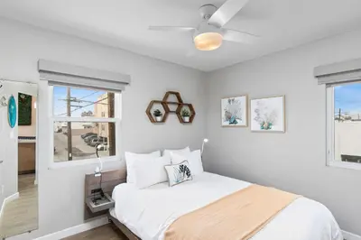 a white bedroom with a bed and a ceiling fan at Modern Newly Renovated 2BR Apt in Heart of Ocean Beach in San Diego