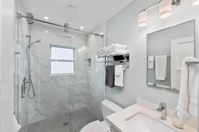 a bathroom with a shower and a toilet and a sink at Modern Newly Renovated 2BR Apt in Heart of Ocean Beach in San Diego