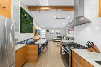 a kitchen and living room with a stove top oven at Modern Newly Renovated 2BR Apt in Heart of Ocean Beach in San Diego