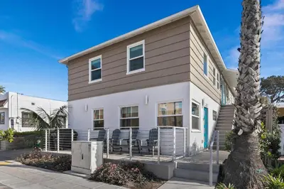 a house with a palm tree in front of it at 7BD Family, Event Friendly, 2 blocks to Beach, Boardwalk in San Diego
