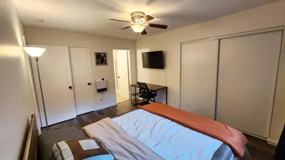a bedroom with a bed and a ceiling fan at Private, Spacious, 4x Queen, 300 MBPS Internet with Backyard! in Hemet