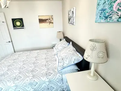 a bedroom with a bed and a lamp on a table at Artsy smart home near Downtown & Balboa Park in San Diego
