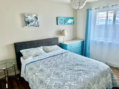 a bedroom with a bed and a blue dresser and a window at Artsy smart home near Downtown & Balboa Park in San Diego