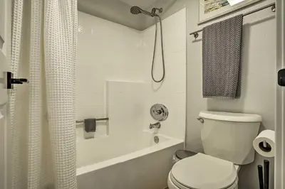a bathroom with a toilet and a tub and a shower at Cozy-Chic Condo Walk to Beach and Park! in Dana Point