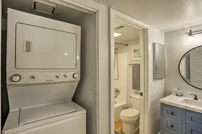 a bathroom with a toilet and a sink and a mirror at Cozy-Chic Condo Walk to Beach and Park! in Dana Point