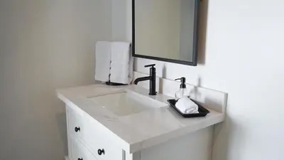 a white bathroom with a sink and a mirror at Hidden Hacienda in Temecula