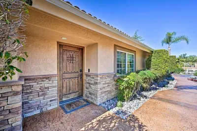 a house with a wooden door on the side of it at Vista Home with Pool about 11 Mi to Tamarack State Beach in Vista