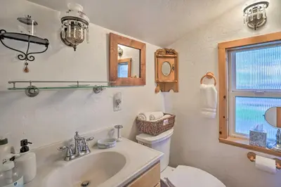 a bathroom with a sink and a toilet and a window at Cozy Story Book Barn Cottage with Scenic View in Julian