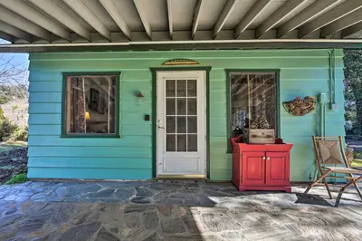 a blue house with a red door and a chair at Cozy Story Book Barn Cottage with Scenic View in Julian