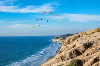 a group of people flying kites over the ocean at On Site Parking King Master Suite UCSD Walk in San Diego