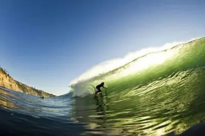 a person riding a wave on a surfboard in the ocean at Private Room2 Own Entry Shared Bath One Guest Walk to UCSD in San Diego