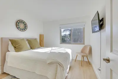 a white bedroom with a bed and a window at Bright Townhome in Carlsbad 1 Mile to Beach! in Carlsbad