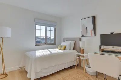 a white bedroom with a bed and a desk with a computer at Bright Townhome in Carlsbad 1 Mile to Beach! in Carlsbad